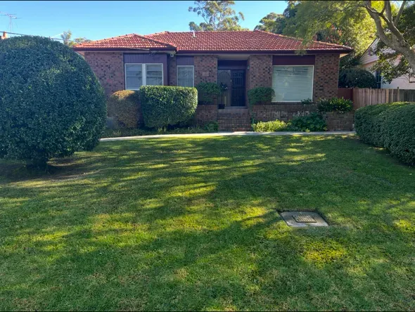 Front lawn mowed in front of a red-brick house on the Upper North Shore