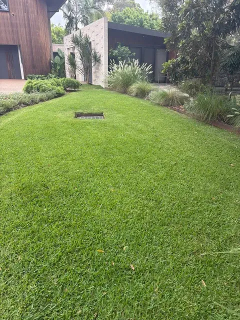 Striped freshly mowed lawn beside a garden bed on the Upper North Shore