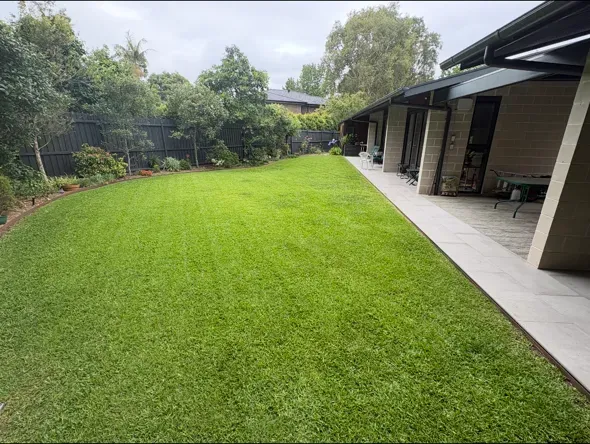 Long back lawn freshly mowed beside a paved patio